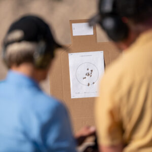 Student has shot a nice target during her firearms training with Ministry of Defense. She and Bryan discuss handgun technique.